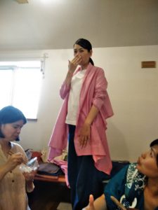 TAKSUAMANATの服を試着している女性